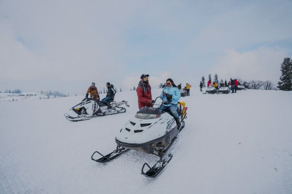 Snowmobilers riding on a snowy trail in winter