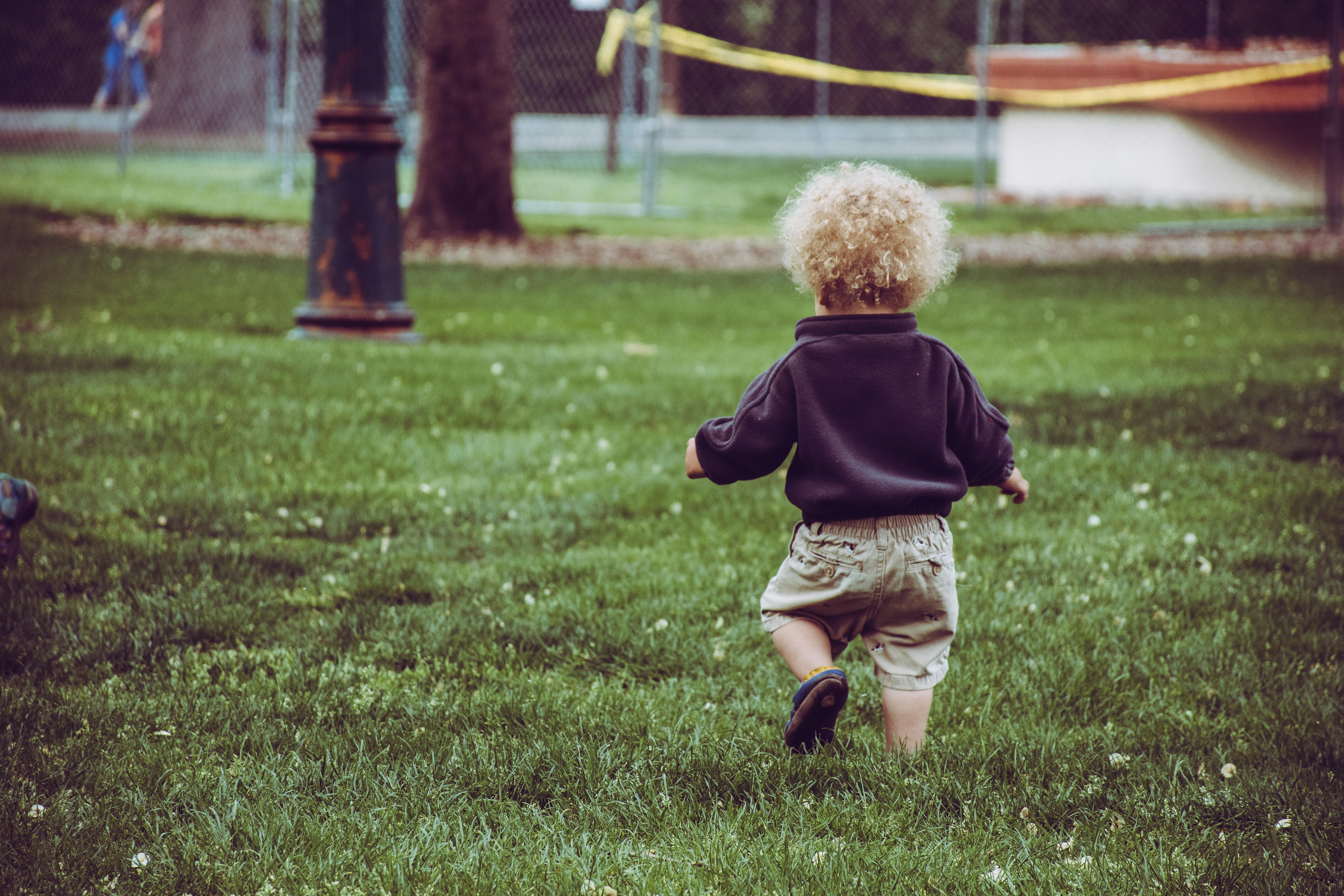Boy Wearing Brown Shorts Standing on Green Grass