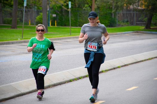 晴朗的日子里，两名妇女在户外慢跑，参加当地的一场比赛