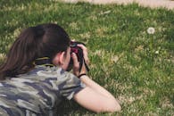 一名身穿迷彩服的妇女在草地上拍了一张特写照片