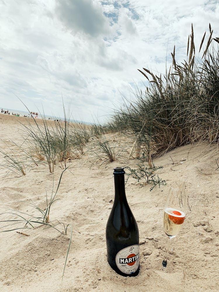 Bottle And Glass Of Martini On Beach