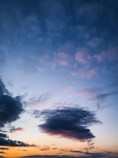 Free A beautiful sunset scene with vibrant clouds and a clear sky, perfect for backgrounds. Stock Photo