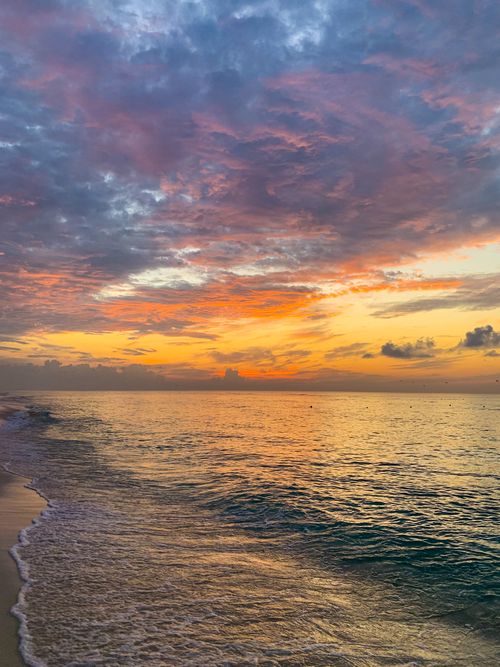 Free Breathtaking sunset over a tranquil ocean with colorful clouds and serene waves. Stock Photo