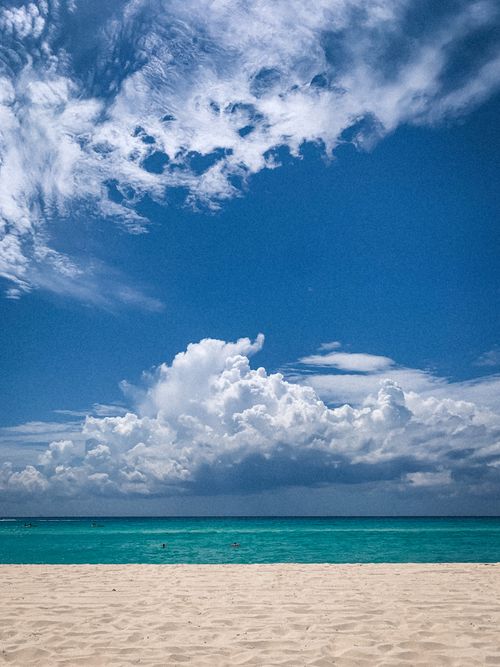 Free Idyllic beach vista with turquoise water and dramatic clouds under a blue sky. Stock Photo