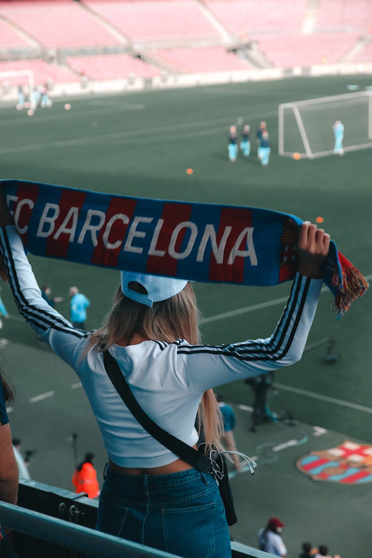 Back View Of A Woman Supporting A Football Team On A Stadium