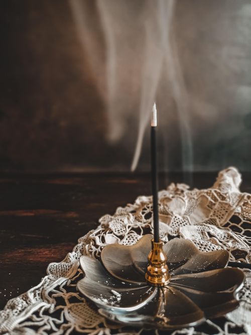 Free Elegant incense burning on a decorative holder with smoke wafting, creating a tranquil scene indoors. Stock Photo