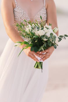 A bride elegantly holding a white floral bouquet in St. Petersburg, FL, perfect for a coastal wedding vibe.
