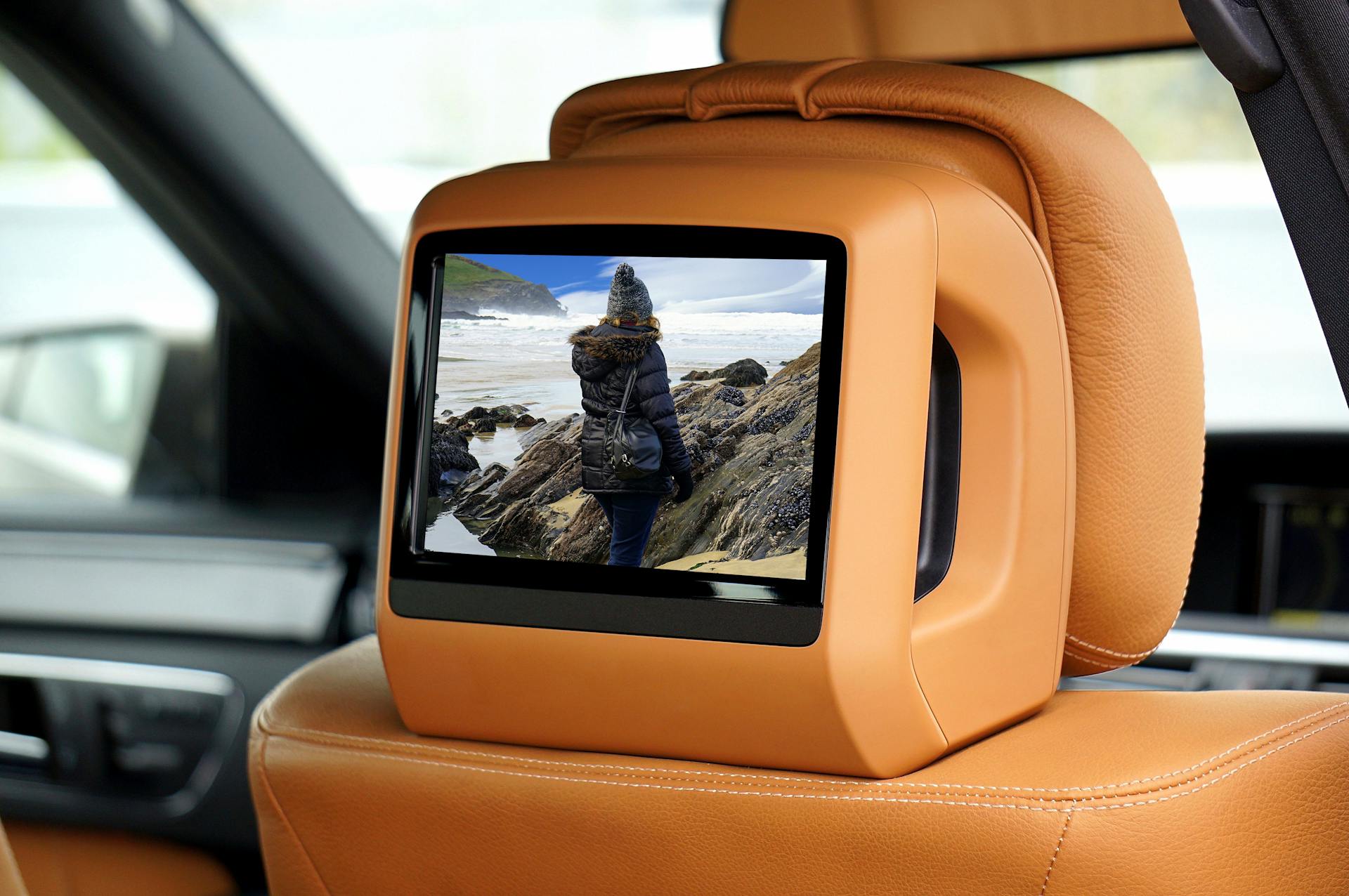 A luxury car interior showcasing a built-in screen displaying scenic landscape.