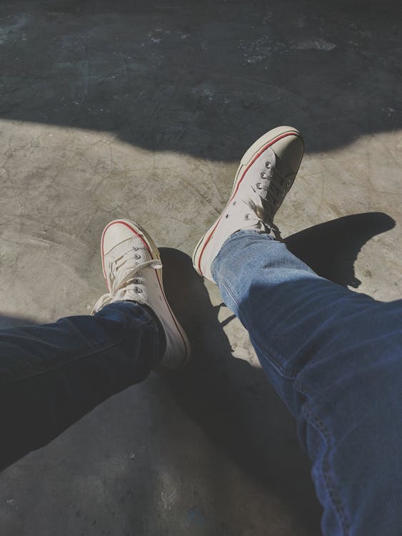 A Person Wearing Jeans and White Shoes · Free Stock Photo