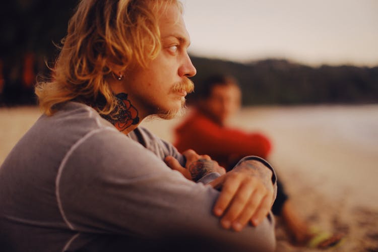 Pensive Bearded Man Sitting On Beach