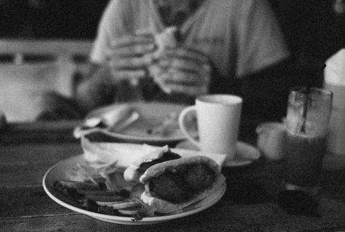 Free Black and white close-up of a meal with cup on a wooden table. Stock Photo
