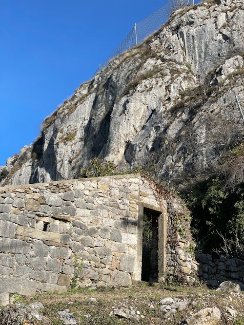 Free Low-Angle Shot of an Abandoned Concrete Building near a Rocky Cliff Stock Photo