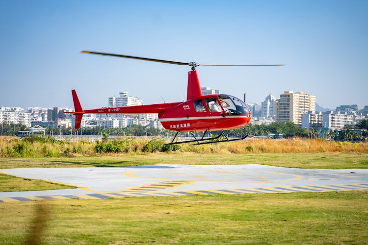 Pilots Inside A Red Helicopter Landing On Ground