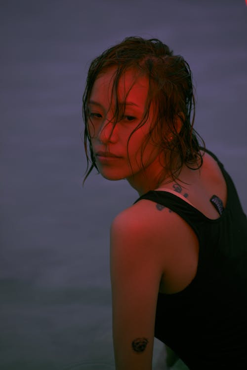 Woman in Black Tank Top Looking Over Her Shoulder Close-Up Photo