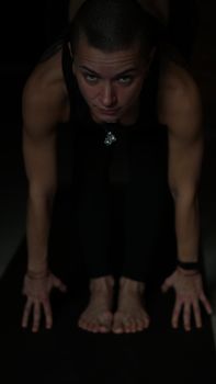 A woman performing an intense yoga stretch indoors with focused expression. Perfect for wellness themes.
