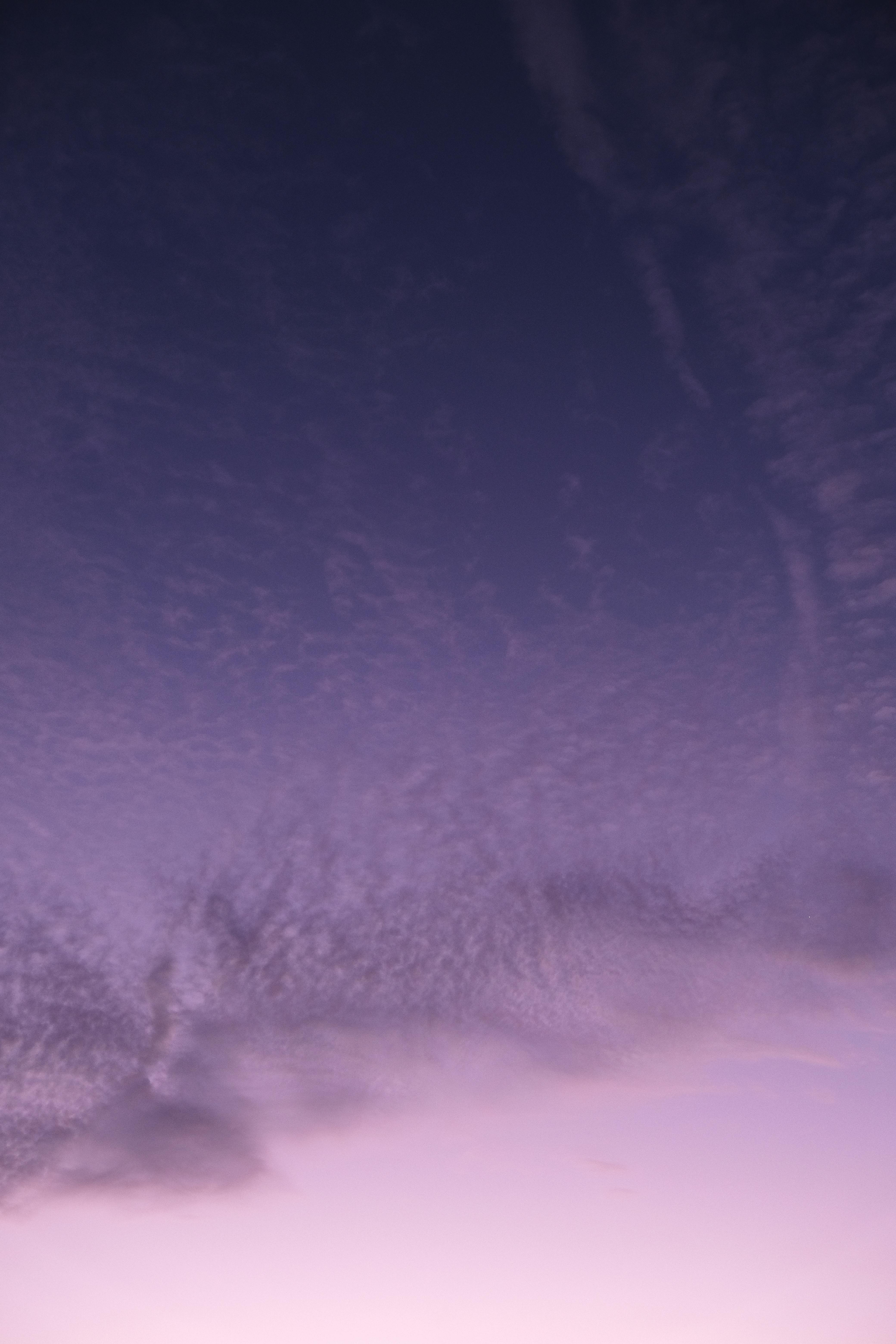 A serene twilight sky in Nouvelle-Aquitaine, France, featuring soft purple hues and picturesque cloud formations.