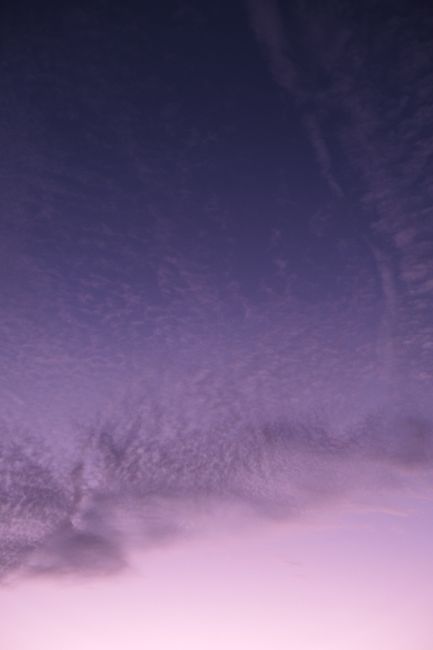 A serene twilight sky in Nouvelle-Aquitaine, France, featuring soft purple hues and picturesque cloud formations.