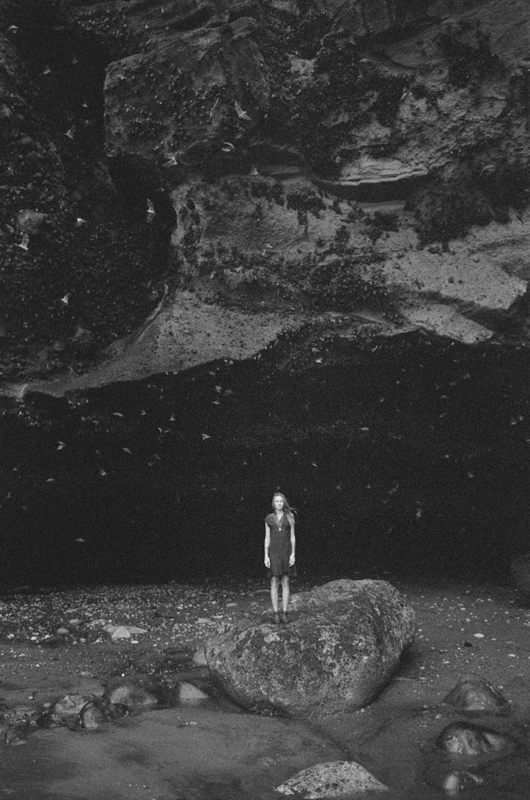 Woman Standing On Rock On Seashore At Night