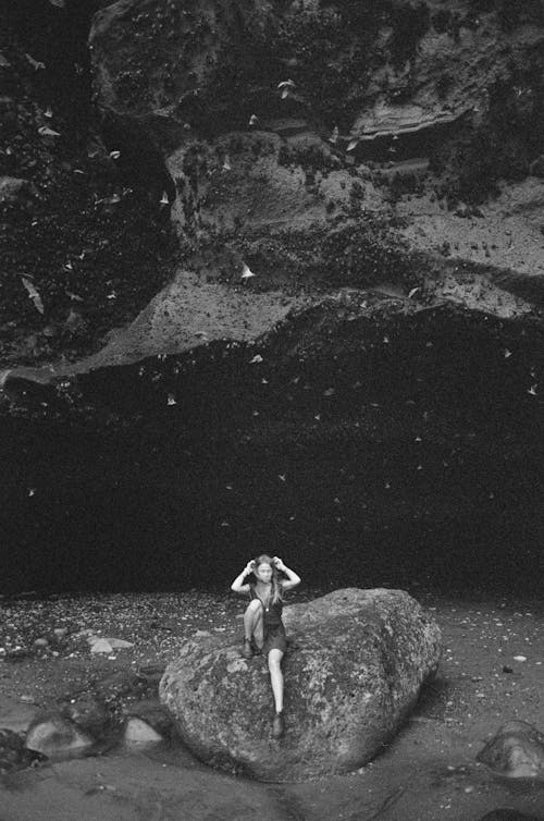 Free Grayscale Photo of Woman Sitting on a Rock Stock Photo