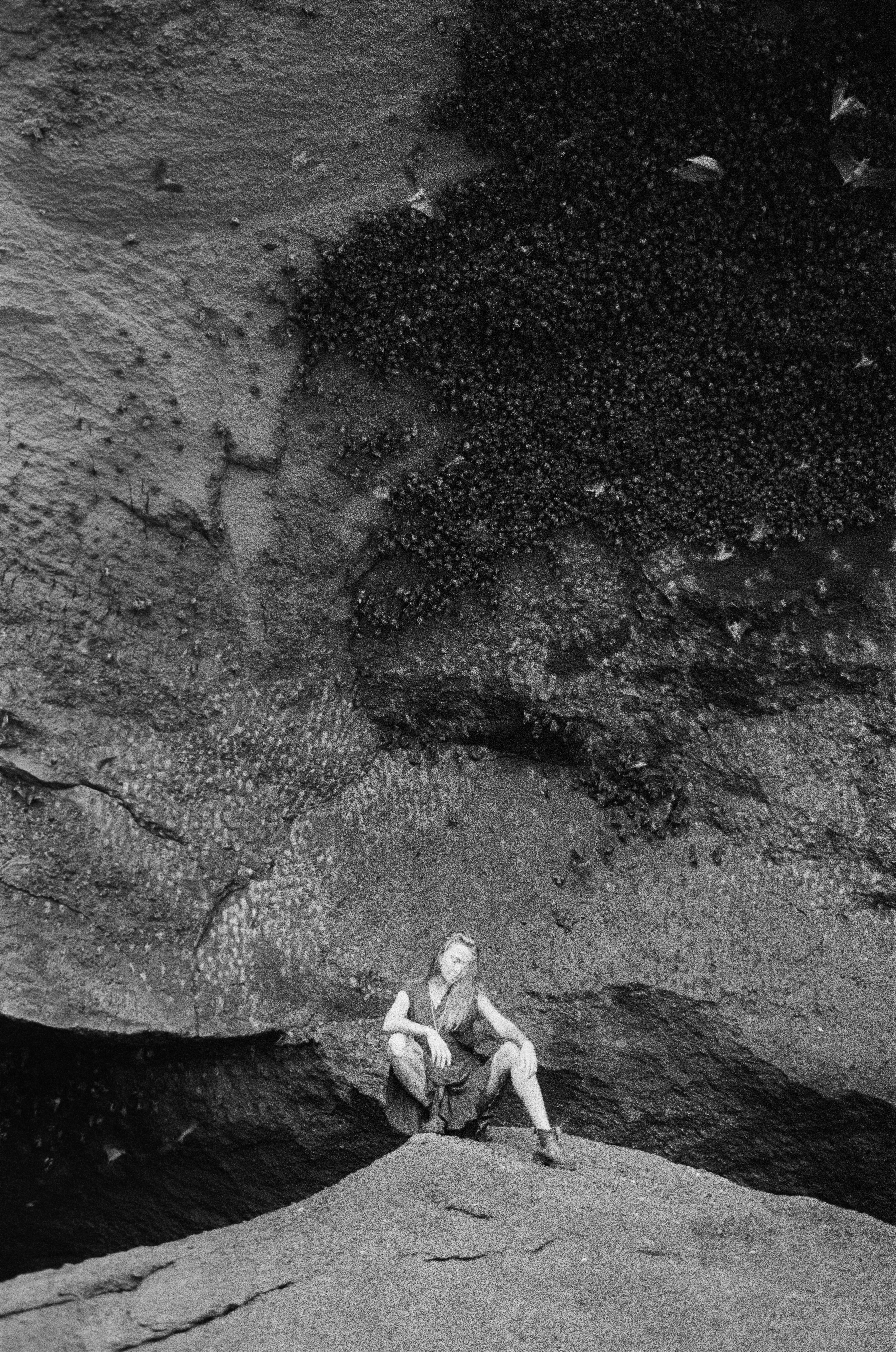 Grayscale Photo of a Woman in Black Dress Sitting on Rock · Free Stock ...