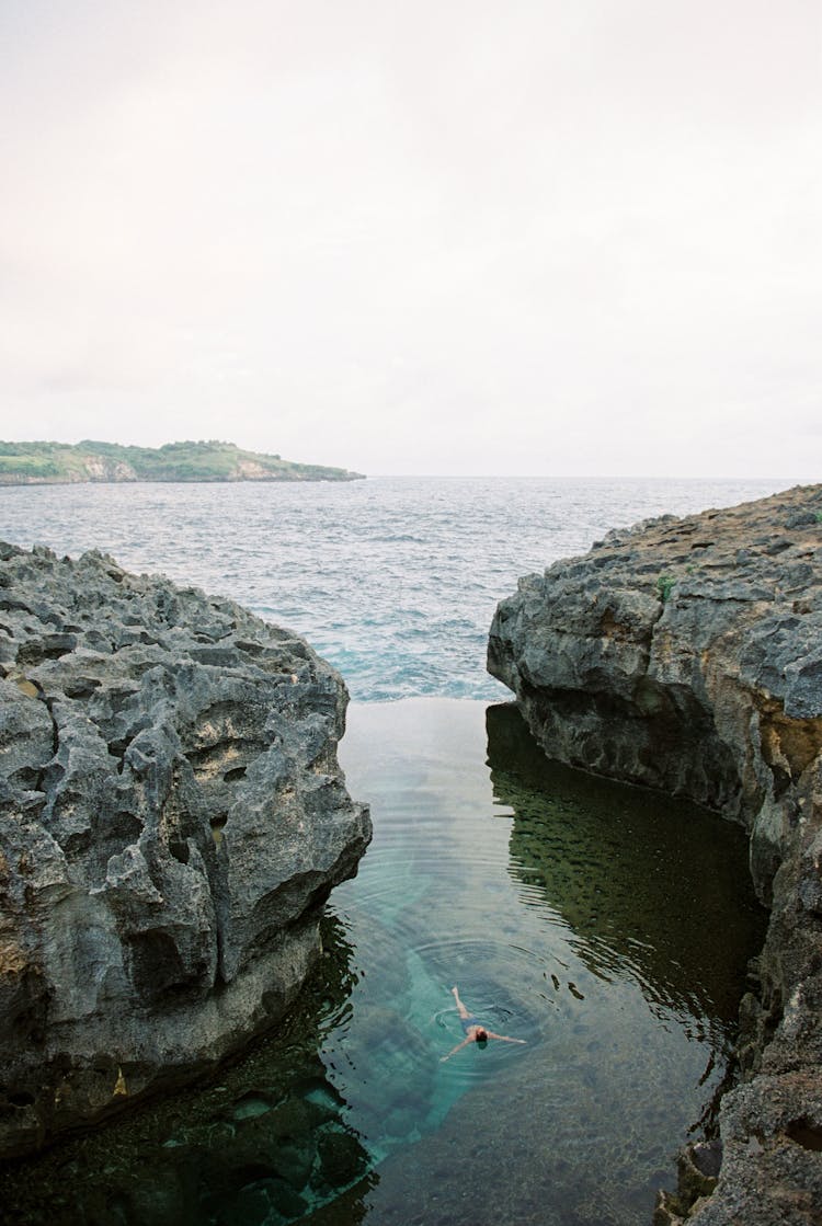 Person Swimming In An Inlet Body Of Water