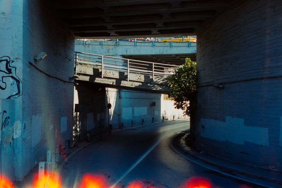 Concrete urban underpass with graffiti, featuring sunlight casting shadows.