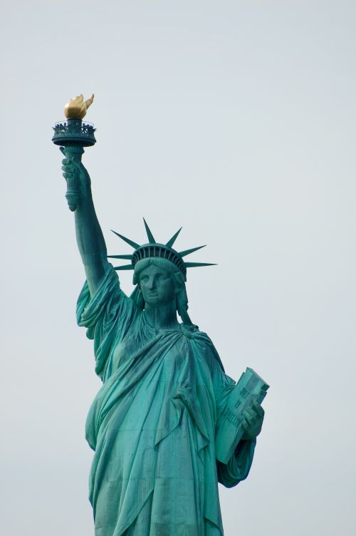 Free Iconic Statue of Liberty symbolizing freedom with a clear sky backdrop in New York. Stock Photo