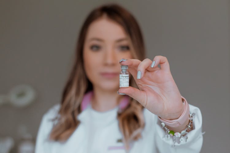 A Woman Holding A Vial