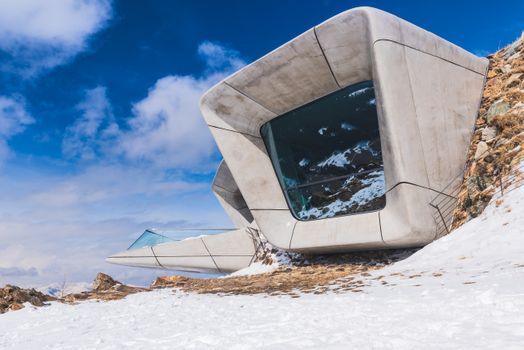 Modern architectural marvel of Messner Mountain Museum Corones amidst snowy mountain terrain under a clear sky.