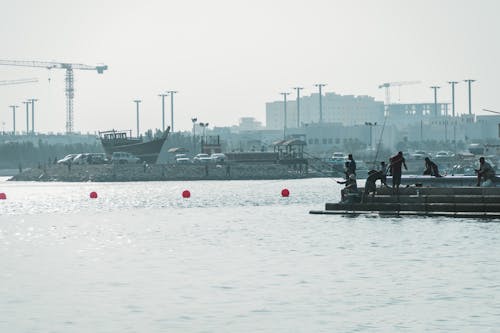 Balık tutmak, balık yakalamak, balıkçılar içeren Ücretsiz stok fotoğraf