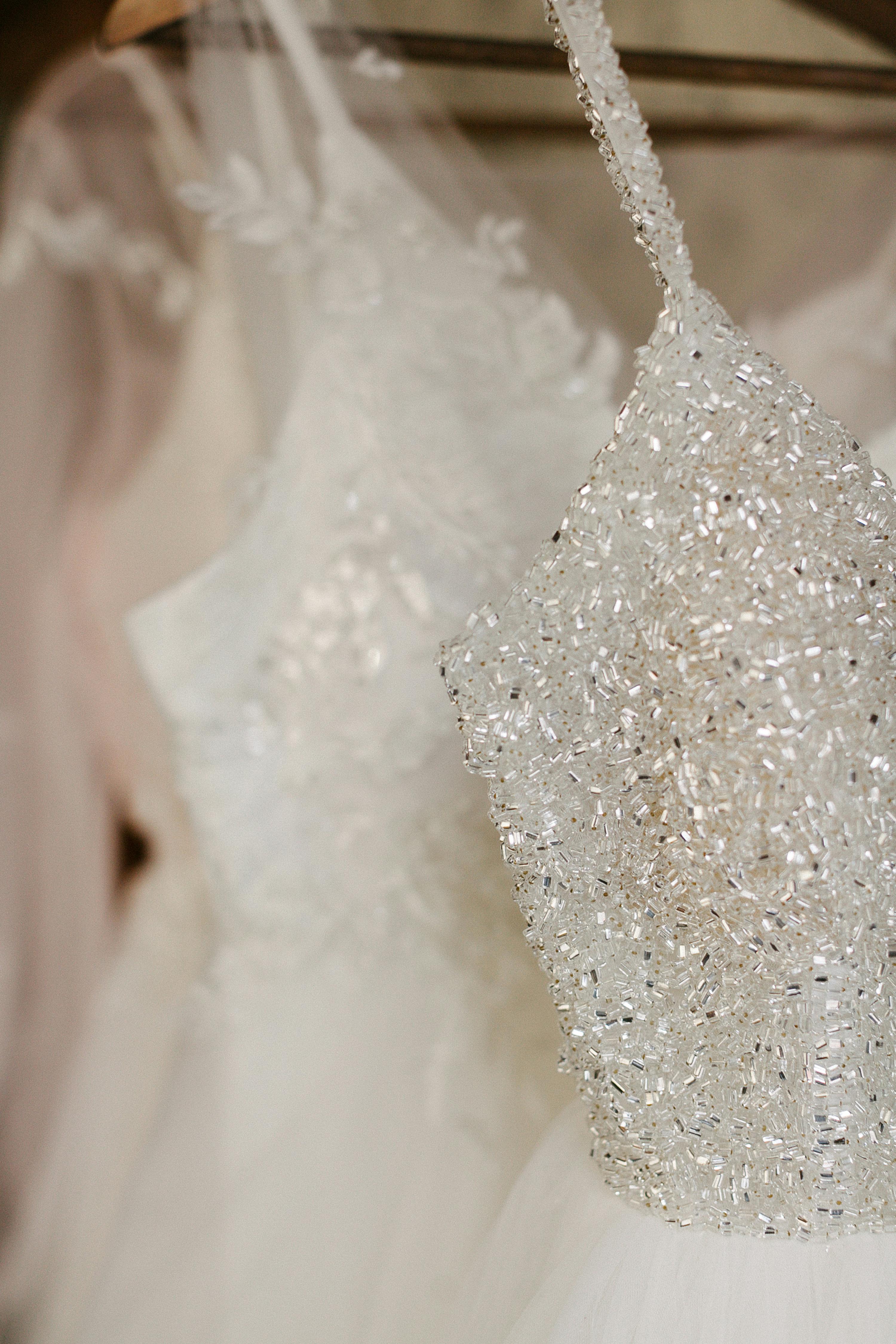 Close-up of a beaded wedding gown with spaghetti straps, capturing elegance and detail.