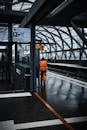 Man in Orange Jacket Standing on Train Station