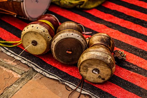 Free Close-up view of traditional Indian dhol drums placed on a vibrant striped rug, showcasing musical culture. Stock Photo