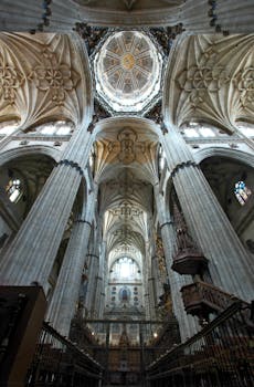 Vertical view of the ornate gothic arches and dome in Salamanca Cathedral, Spain.
