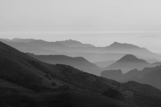 Black and white view of Corsican mountains with mist creating a serene landscape.