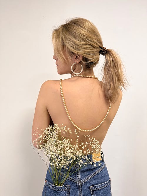 Back View of a Shirtless Woman with Flowers in Her Pockets 