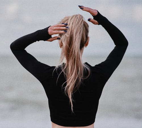 Woman in Black Top Touching Her Hair