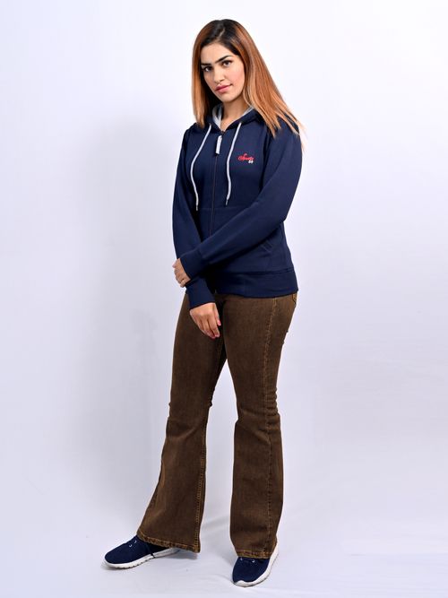 Free Woman in casual blue hoodie and brown pants against white background. Stock Photo