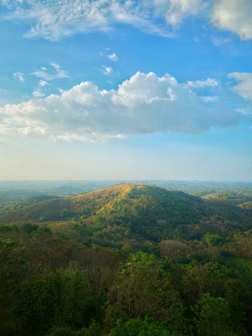 Free Breathtaking aerial view of lush hills beneath a blue sky in summer. Stock Photo