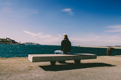 Free Person Wearing Blue Jeans Sitting on Bench Stock Photo