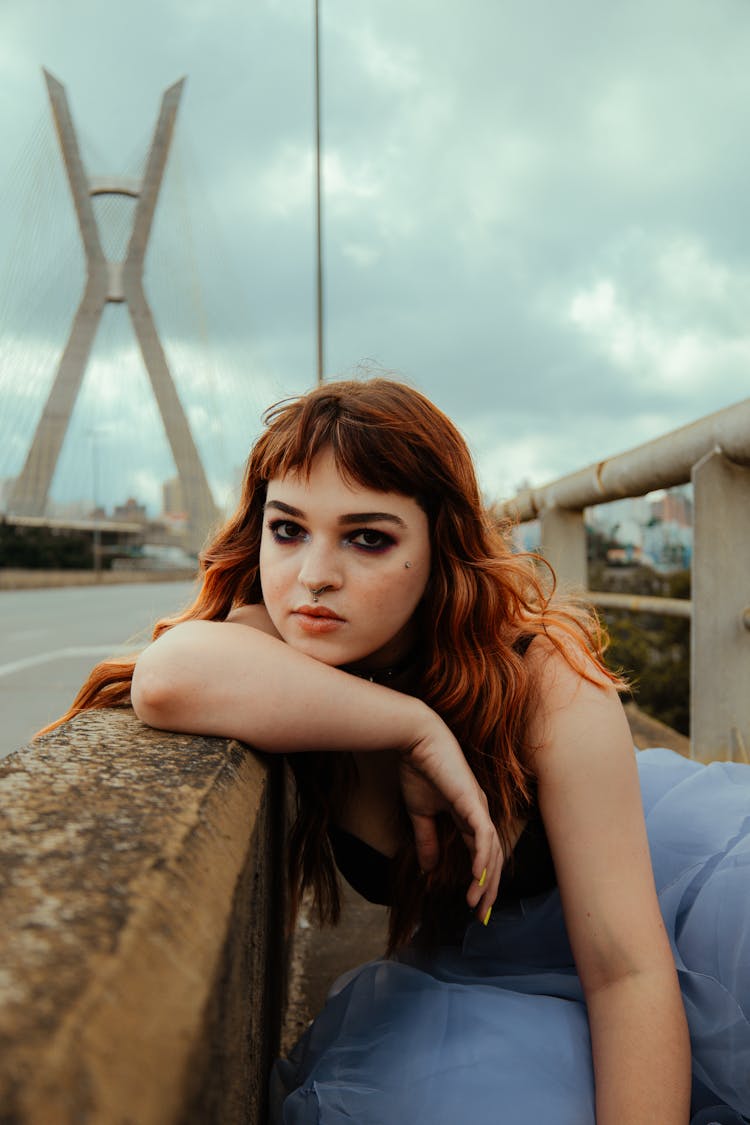 Young Woman Leaning Arms On Concrete Fence Barrier On Road