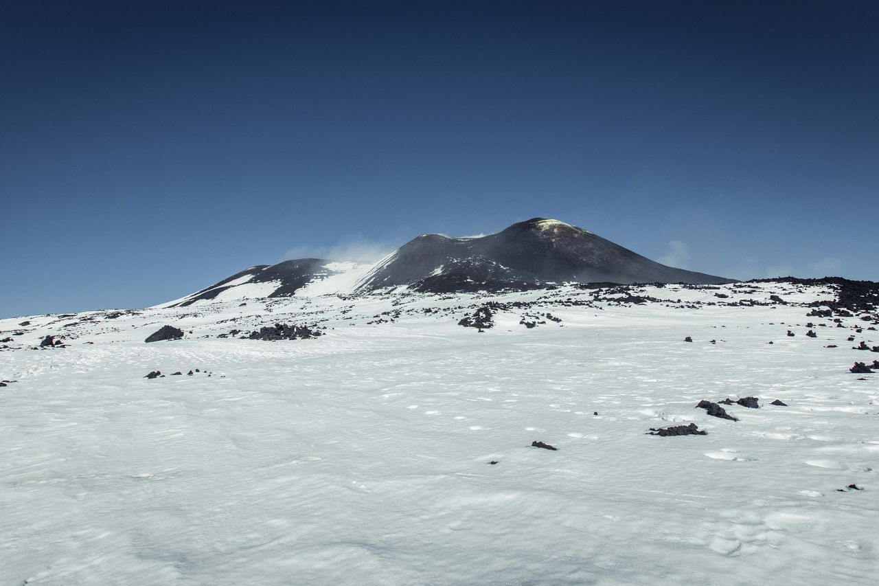 Snow on the upper slopes of Mount Etna under a clear sky