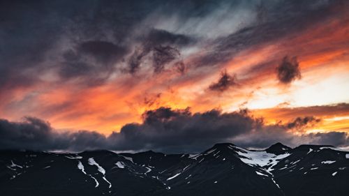 Free Stunning sunset over Iceland's snowy mountains with dramatic clouds. Stock Photo