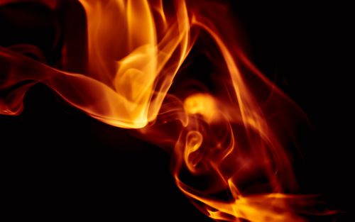 Free Vibrant orange flames dance against a dark background, showcasing the dynamic beauty of fire. Stock Photo