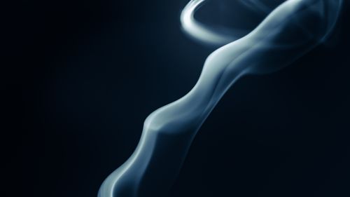 Free A mesmerizing close-up of swirling smoke patterns against a dark background, creating an abstract visual effect. Stock Photo