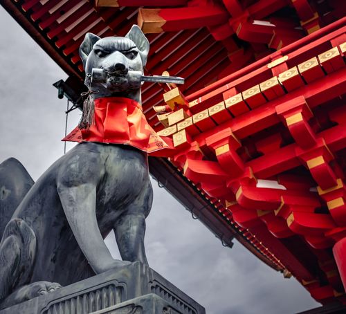 Free Fox statue at the iconic Fushimi Inari Taisha shrine in Japan, showcasing traditional Japanese architecture. Stock Photo