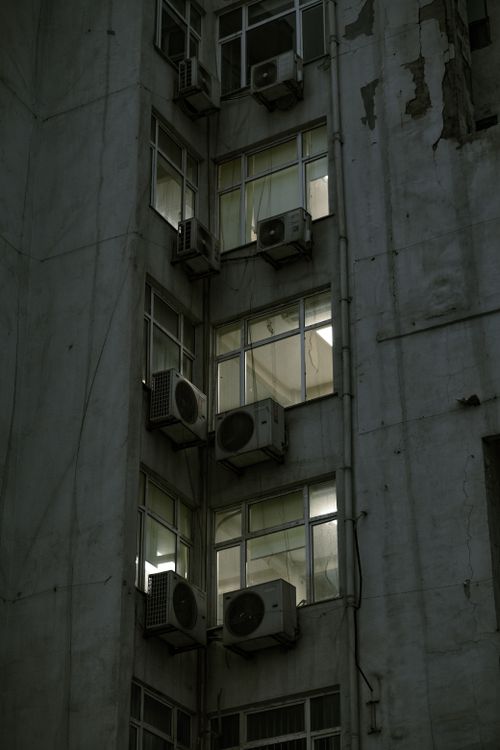 Free Low-angle view of an urban building facade with multiple air conditioners attached. Stock Photo