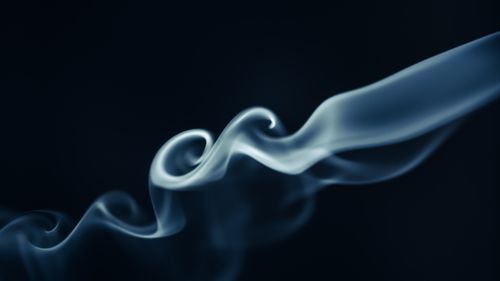 Free Elegant swirling smoke creating abstract forms on a dark background. Stock Photo