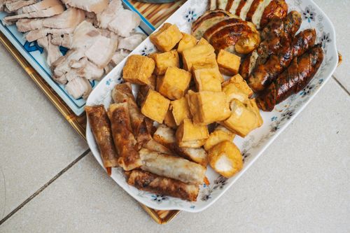 Free A variety of Asian dishes including meats, tofu, and spring rolls served on decorative plates. Stock Photo