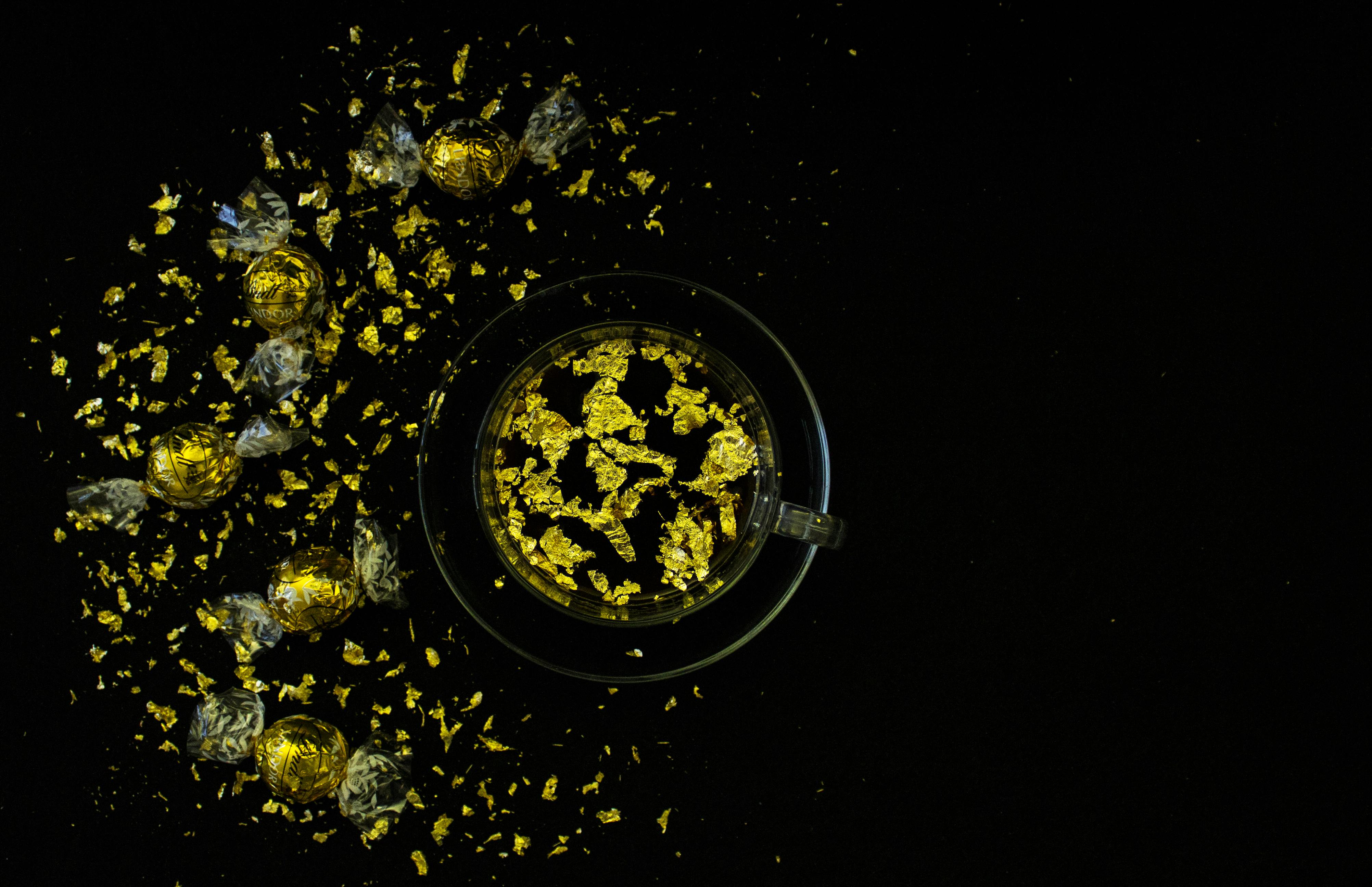 glass cup beside gold chocolates